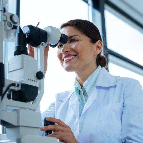cheerful-female-doctor-looking-into-the-microscope.jpg